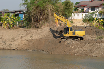 Backhoes digging sand with shovels .from the River