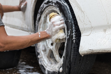 Fototapeta na wymiar A man cleaning a white car