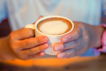 hands holding cup of coffee
