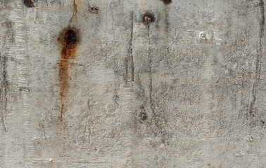 Old grey outdoor concrete wall texture background with broken plaster showing rusty steel  inside 