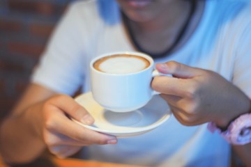 woman holding cup of coffee in front of her