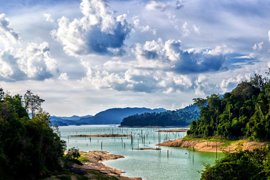 A landscape of Kenyir Lake, Terengganu, Malaysia. Dead woods, turquoise water and lush green tropical rainforest.