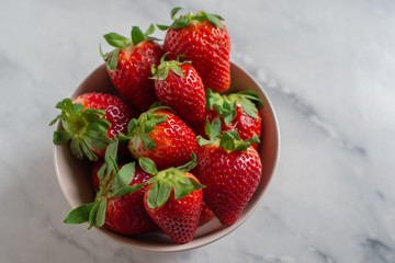 Fresh strawberries in the mug on the wooden table