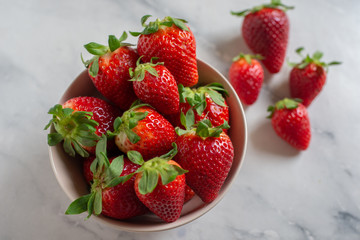 Fresh strawberries in the mug on the wooden table