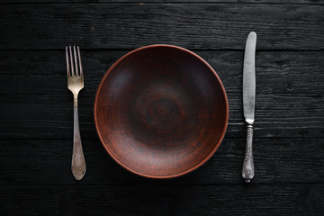 Clay dishes. A plate on a black background. Top view. Free copy space.