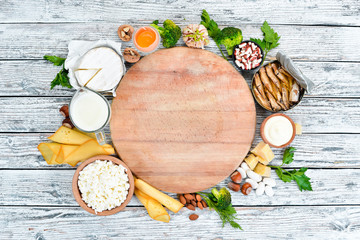 Fototapeta na wymiar Dietary food. Healthy food: cheese, milk, parmesan, sour cream, fish, almonds, parsley, garlic, broccoli. Top view. Free copy space.