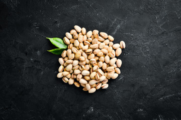 Pistachios on a black background. Top view. Free space for your text.