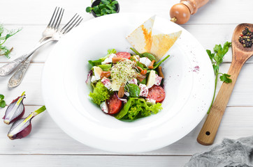 Vegetable salad with brie cheese, cherry tomatoes and spinach. In the plate. Top view. Free space for your text. Rustic style.