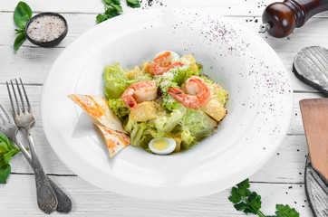 Vegetable Caesar Salad with Shrimp. In the plate. Top view. Free space for your text. Rustic style.