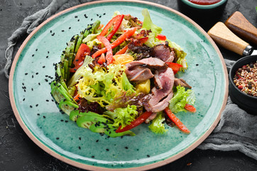 Vegetable salad with avocado and veal. In the plate. Top view. Free space for your text. Rustic style.