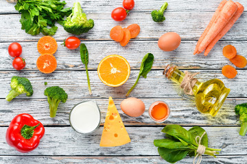 Healthy foods, fruits and vegetables. Broccoli, Carrots, milk, cheese, spinach, dried apricots, parsley, tomatoes. Top view.