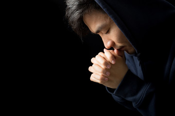 Praying Man Against Dark Background With Copy Space