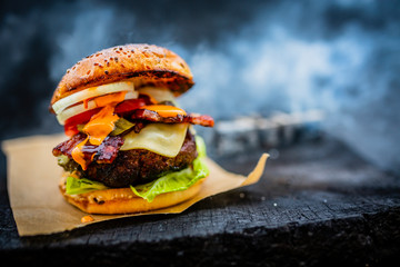 Tasty smoked grilled and glazed beef burger with lettuce, cheese and bacon served with french fries...