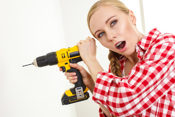 Woman having troubles using drill