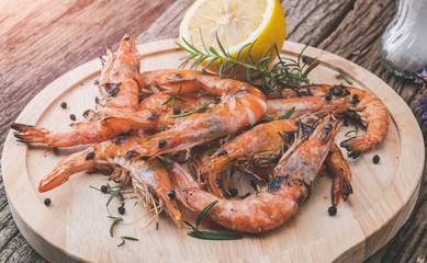 Shrimps or prawns grilled in wooden plate.
