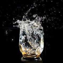 Coins falling splashing into a water glass