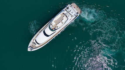 Aerial drone bird's eye top view photo of luxury yacht with wooden deck docked in deep blue waters...