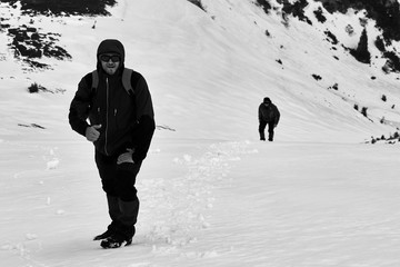 Fototapeta na wymiar tourist mountaineer climbs over the snowy mountains to the summit