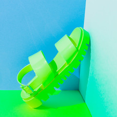 Fashionable art set with plastic neon green sandals in bright duotone colors. Strong shadows.