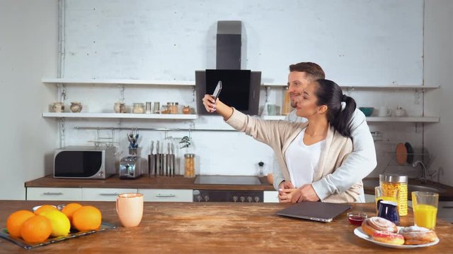 Millennials use smartphone taking selfie photo. Lovely couple take photos while having breakfast.