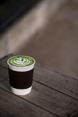 hot matcha green tea latte take away cup on wood table