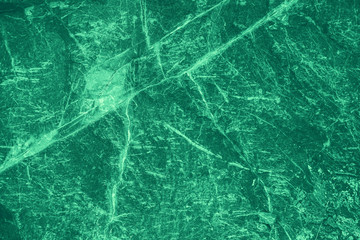 Vintage green background. Rough painted wall of emerald color. Imperfect plane of virid colored. Uneven old decorative toned backdrop of green tint. Texture of emerald hue. Ornamental stony surface.