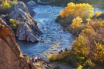 View from the mountain on rowers kayakers in whitewater river on a sunny autumn day