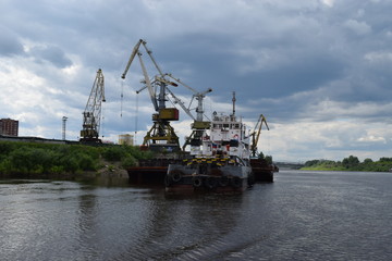 Fototapeta premium Unloading the ship in the Tyumen river port. Tura River, Tyumen, Russia