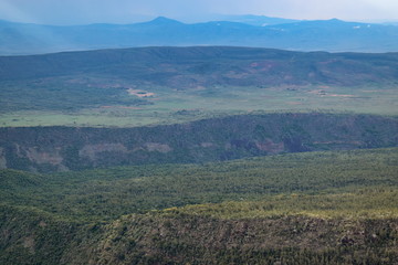 Fototapeta na wymiar Volcanic crater against a mountain background, Mount Suswa, Kenya