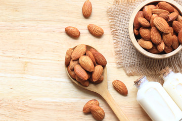 Almond in a bowl with almonds milk in glass bottle on the table with copy space