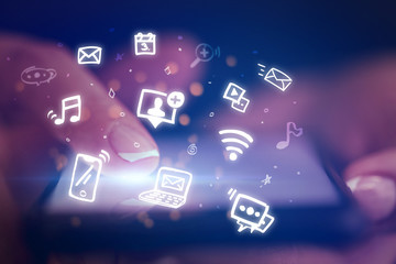 Finger touching phone with hologram application icons and dark background
