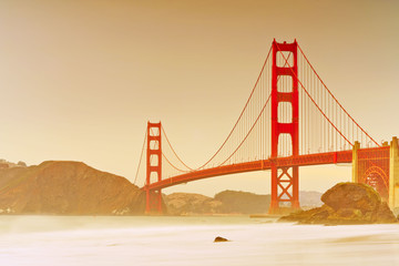 View of Golden Gate Bridge from Marshall's Beach in San Francisco at sunset.