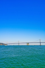 View of Bay Bridge across San Francisco Bay in San Francisco on a sunny day.