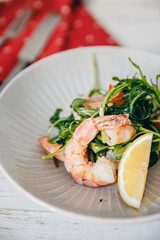 Fresh Salad with shrimps, arugula, lemon, tomatoes from bio products. Top view