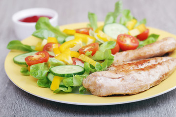 Grilled chicken breast with raw vegetables salad