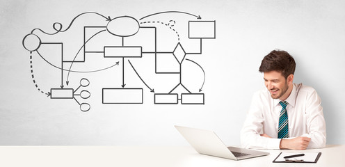 Businessman sitting at desk and presenting organizational chart
