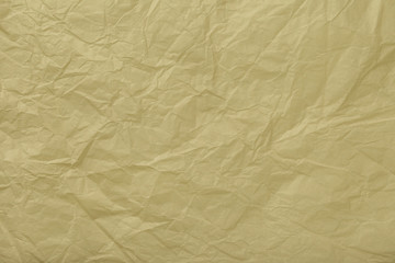 Texture of crumpled beige wrapping paper, closeup. Golden old background
