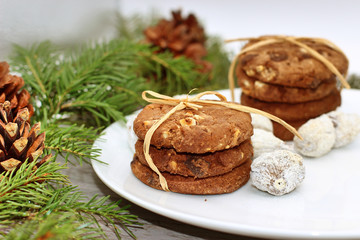 Fototapeta na wymiar Christmas decorations - oat biscuits for Santa Claus and branches of coniferous trees