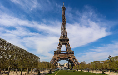 Fototapeta na wymiar Eiffel Tower in Paris France against blue sky with clouds. View from a tourist bus. April 2019