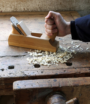 hand of worker  in the carpentry workshop with a plane