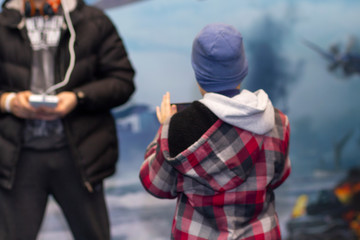 Man and boy is playing videogame in 3D virtual reality simulator using headset