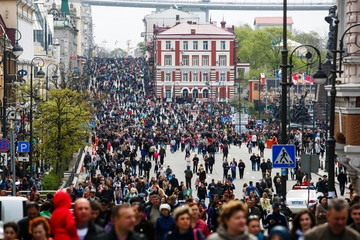 Residents of Vladivostok celebrate Victory Day. People walk along the blocked central street of the...