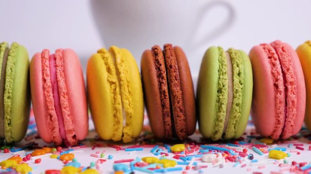 Sweet macaroons with multi colored confectionery dressing. Slide from right to left. Close up.