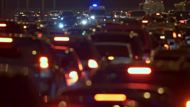 Cars going slowly in a traffic jam during rush hour in the evening in a big city. Beautiful abstract sight of blurred car lights. 4K