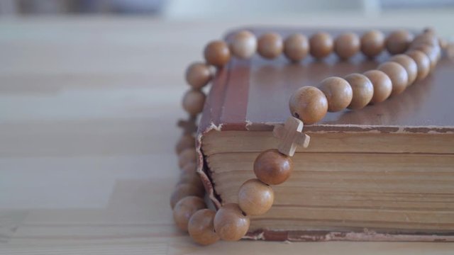Close up rosary lying on Bible