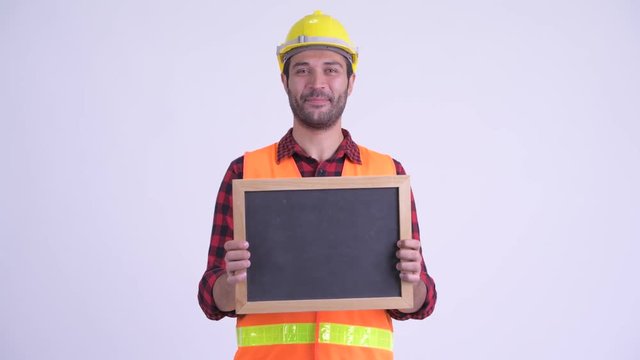 Happy bearded Persian man construction worker holding blackboard