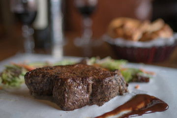 Sirloin steak on cutting board and paper. Eating and leisure concept. Roasted beef. Delicious hot beef steak. Grilled beef steaks with vegetables. Organic healthy food. Toned image. Selective focus.