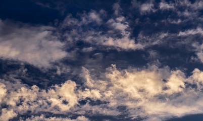 Obraz premium cumulus and cirrus clouds against the evening blue sunset sky