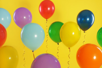 Bright balloons on color background. Celebration time