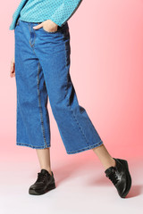 Naklejka premium Fashionable woman in stylish shoes on color background